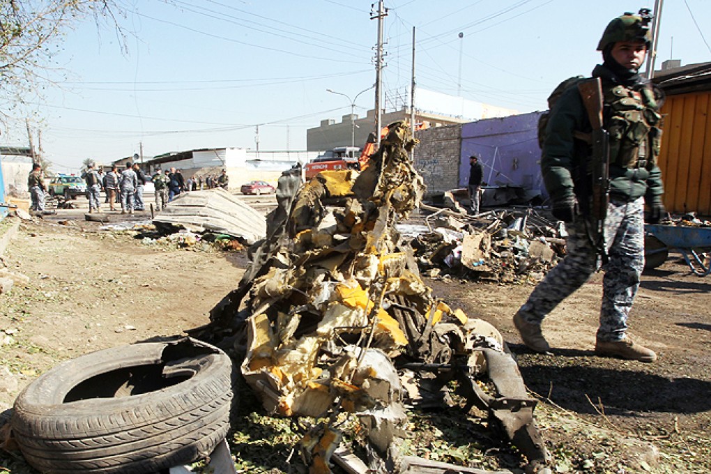 An Iraqi soldier walks past debris at the site of a car bomb explosion in the industrial Camp Sarah district of central Baghdad on Thursday. Photo: AFP