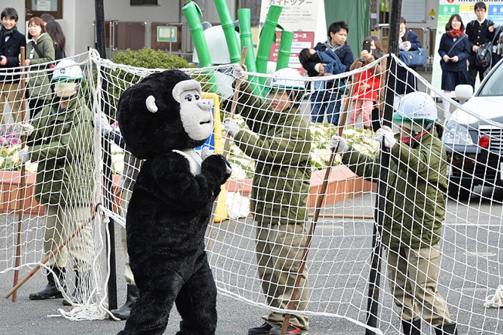 Zookeepers hold a net to capture an animal keeper dressed in a gorilla costume during a drill to practice what to do in the event of an animal escape at the Ueno zoo in Tokyo on Thursday. Photo: AFP