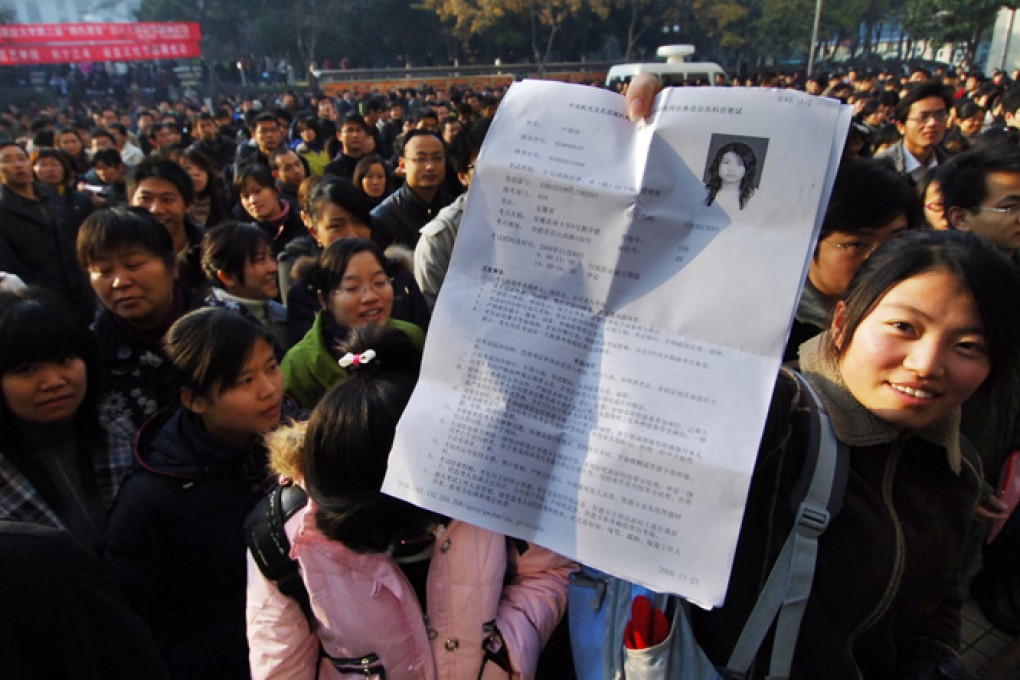 An applicant presents her exam permission prior to the 2009 central government recruitment exam in Hefei, Anhui Province. Photo: Xinhua