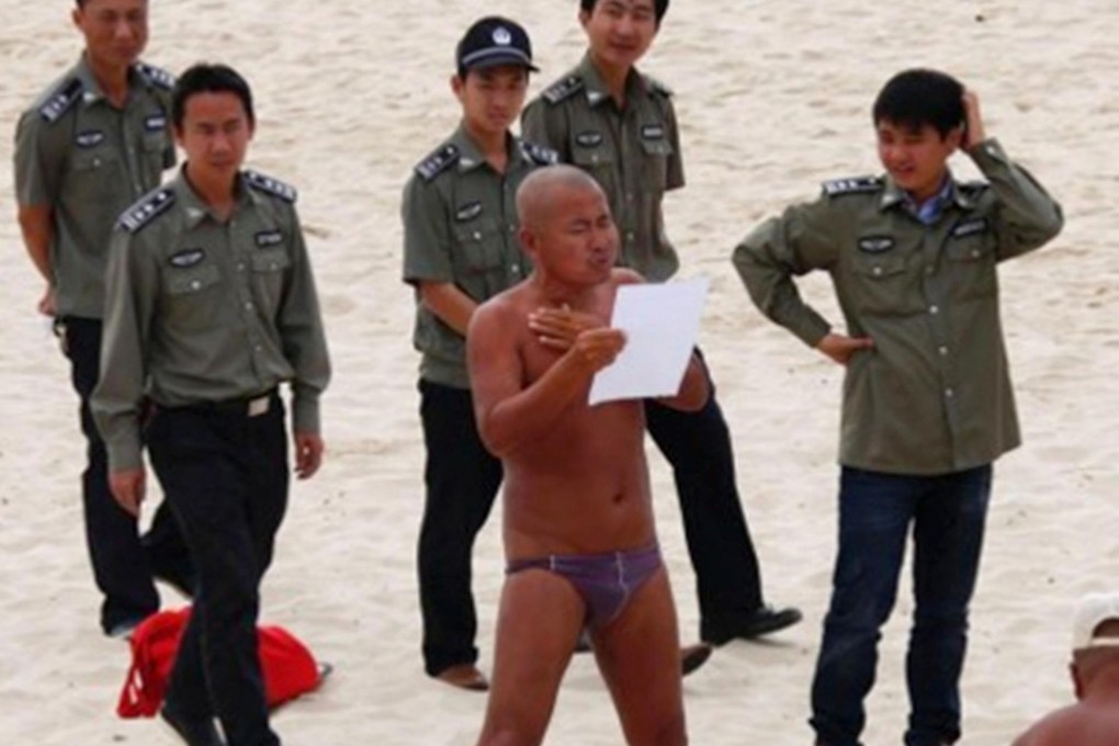 Officials persuade a visitor to cover up on the beach. Photo: CNS