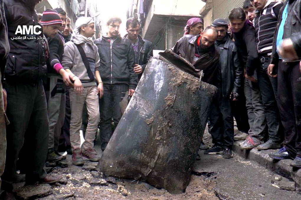 Men inspect an barrel filled with unexploded bombs dropped from a Syrian government helicopter in Aleppo, Syria. Photo: AP