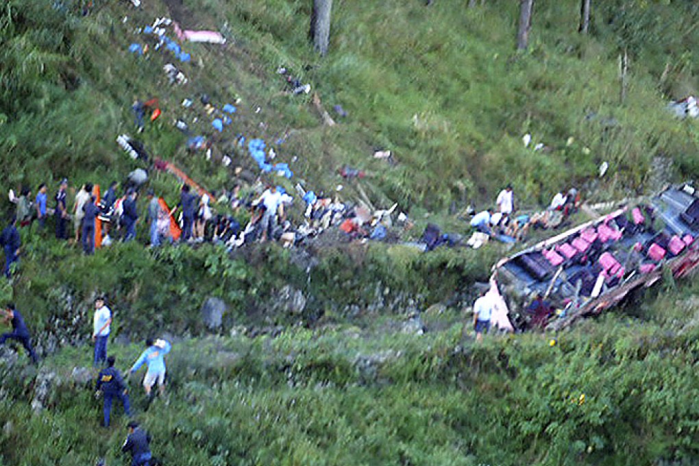 Police and rescuers retrieve bodies of passengers after a bus veered off a mountain road in the northern Philippines on Friday. Photo: AP