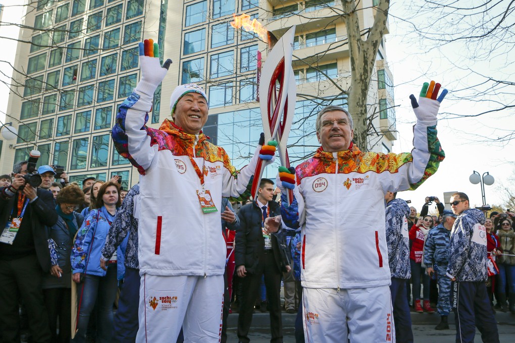 International Olympic Committee president Thomas Bach hands over the Olympic torch to UN Secretary General Ban Ki-moon as the torch relay arrives in Sochi on Thursday for the Winter Olympics. Photo: AP