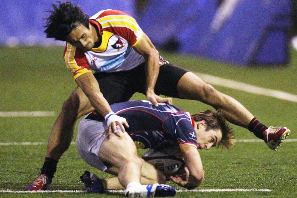 Valley's Salom Yiu Kam-shing tackles Jevon Marsh of Hong Kong Scottish in their Premiership crunch match on Saturday. Photo: Edward Wong