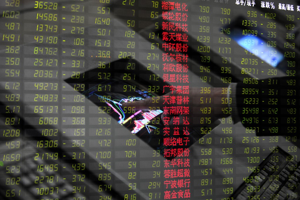 An investor checks stock information at a stock trading hall. Photo: Xinhua