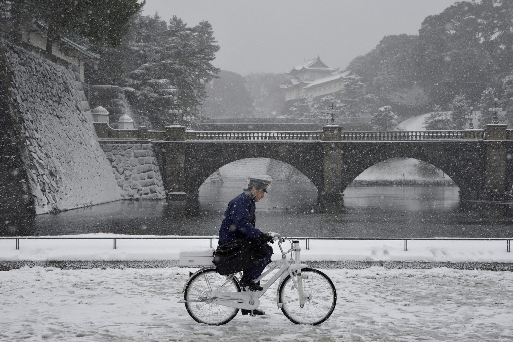 A police officer patrols on a bicycle during heavy snowfall in the surrounding gardens of the Imperial Palace in Tokyo, Japan. Photo: EPA