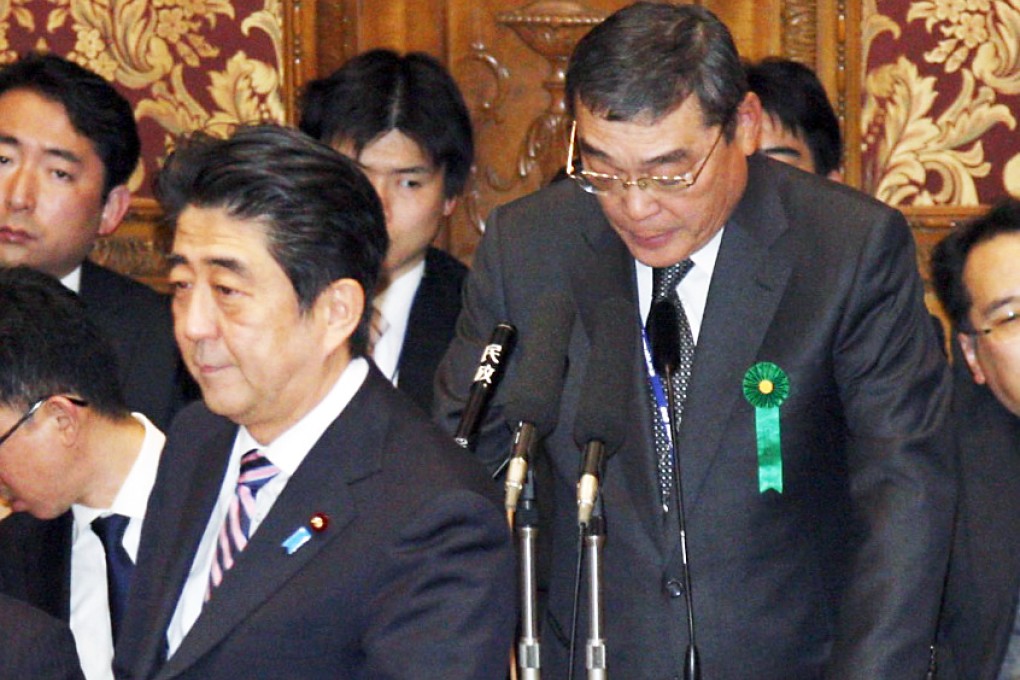 Japan's Prime Minister Shinzo Abe walks by public broadcaster NHK President Katsuto Momii speaking during a budget committee question and answer at the lower house of Parliament in Tokyo. Photo: AP
