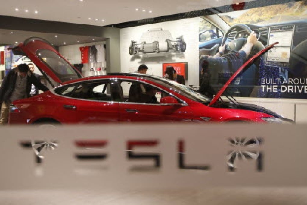 A man looks around Tesla Motors' Model S in a showroom. Photo: Reuters