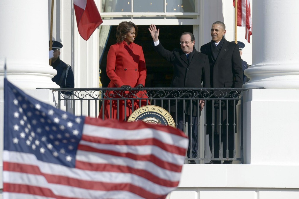 Francois Hollande waves from the White House as hosts Michelle and Barack Obama look on. Photo: AFP