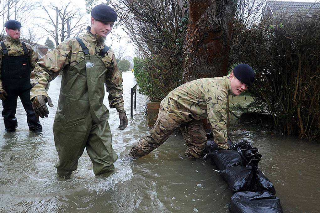 Soldiers attempt to protect a flood-affected property with sandbags in Wraysbury. Photo: AFP