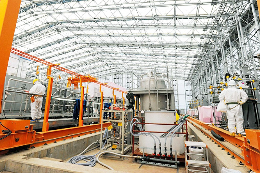 Technicians check a radiation filtering machine used to scrub water clean of most radioactive elements, including cesium and strontium, at the tunami-crippled Fukushima Daiichi nuclear power plant. Photo: Reuters