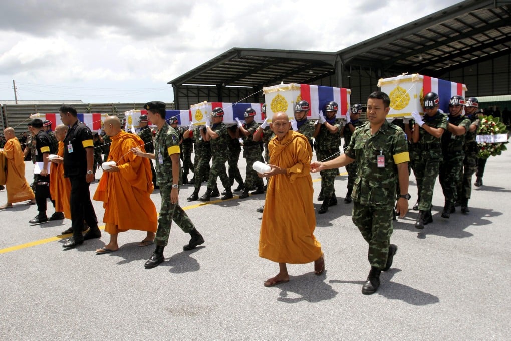 Thai Buddhist monks lead soldiers carrying the coffins of four paramilitary rangers who were killed in a roadside bomb attack last year in Pattani. Suspected Thai militants shot dead five people in the latest attacks in the kingdom’s insurgency-torn deep south. Photo: EPA