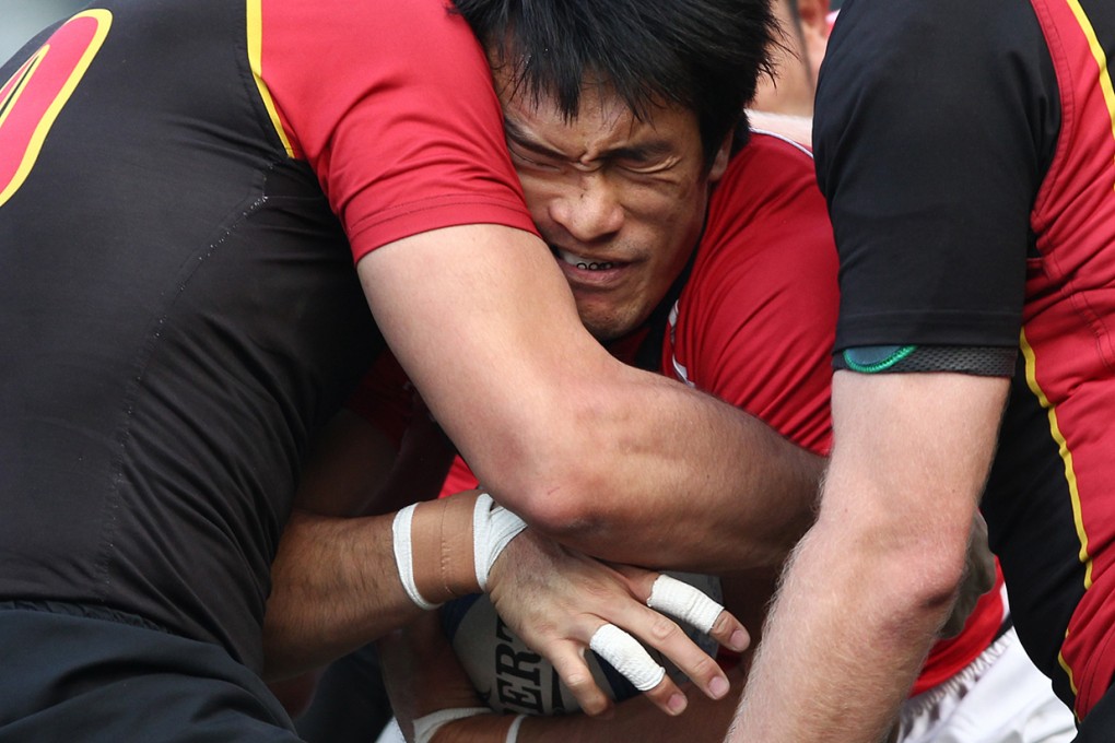 Hong Kong winger Salom Yiu Kam-shing feels the squeeze as he is tackled by a pair of Belgians on Saturday. Photos: Jonathan Wong and HKRFU