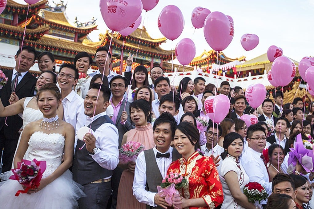 Ethnic Chinese Malaysian couples pose for a group photograph during a mass wedding ceremony at the Thean Hou Temple in Kuala Lumpur, Malaysia, on Friday. Photo: EPA