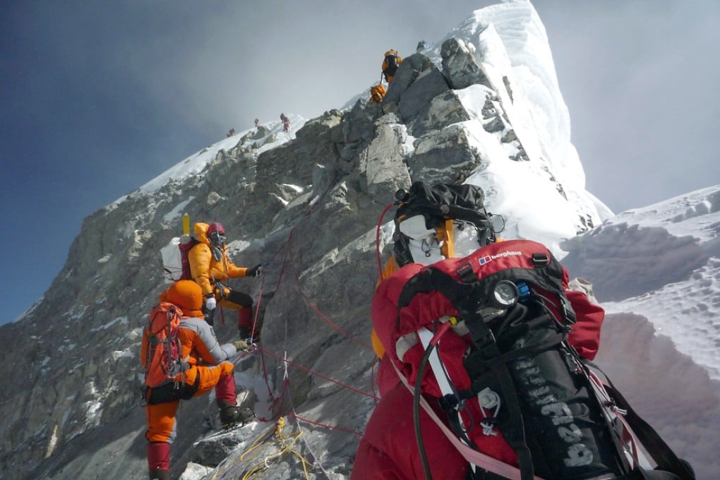 Mountaineers walk past the Hillary Step while pushing for the summit of Everest as they climb the south face from Nepal. Photo: AFP