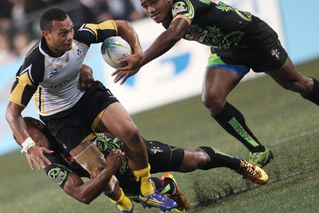 Penguins’ Will Helu is tackled by James Brown of Samurai as Willie Ripia closes in during the 2013 Tens cup final. Photo: SCMP