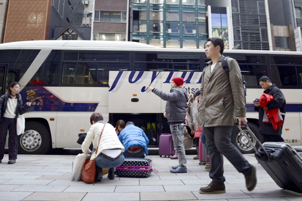 Chinese tourists pack their goodies before loading them onto a tour bus outside a Ginza store in Tokyo. Photo: Bloomberg