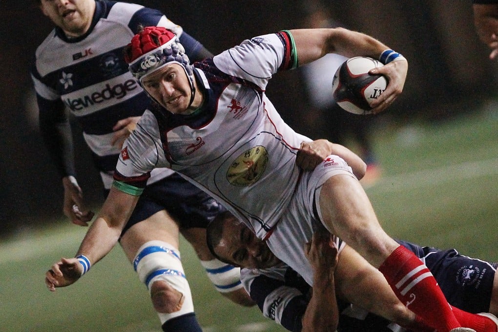 Hong Kong Scottish fullback Dave Whiteford is tackled by Club scrum-half Kenzo Pannell in their clash in Shek Kip Mei. Photo: Felix Wong