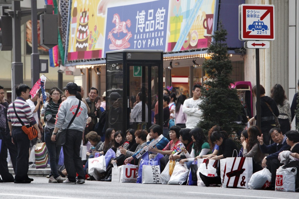 Mainland tourists take a break after shopping in Tokyo's Ginza district. Photo: AP