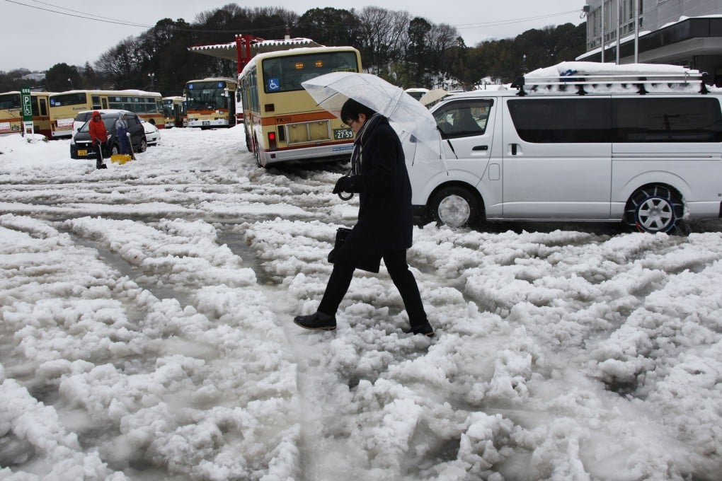 A man walks on a slushy road in Yokohama, near Tokyo. A severe snowstorm sweeping across Japan has killed 19 people and left more than 1,600 injured. Photo: AP