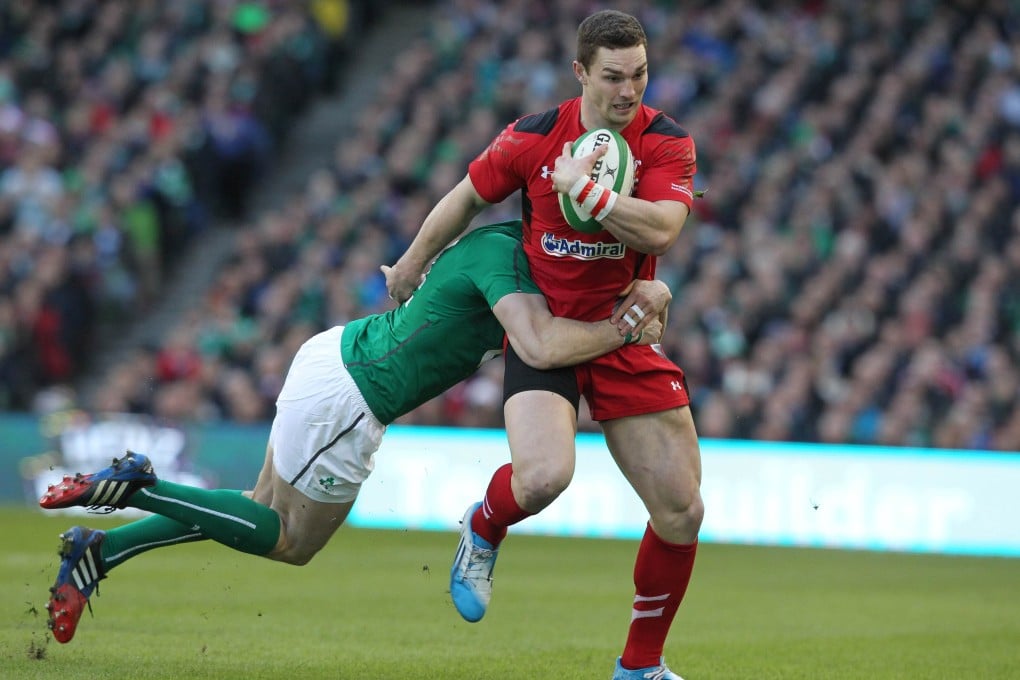 Ireland's Andrew Trimble struggles to get the hulking George North down. Photo: AFP
