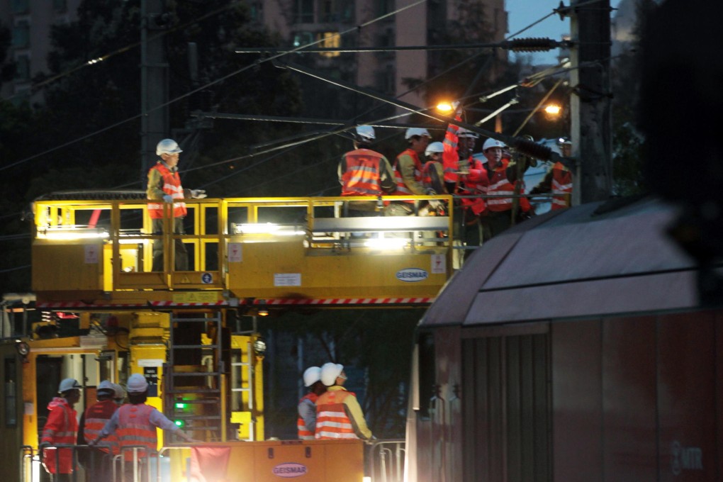 MTR staff repair the electric insulator at Fanling station