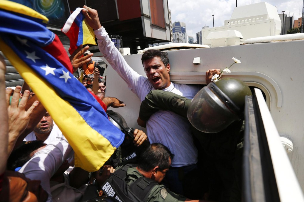 Leopoldo Lopez surrenders to military officers. Photo: Reuters