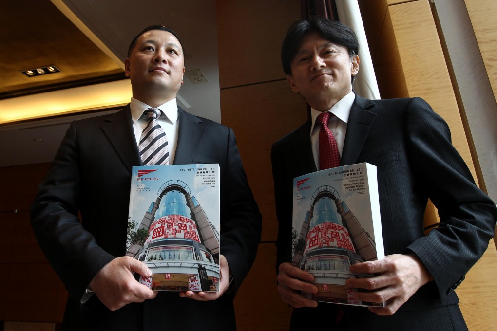 Fast Retailing's Pan Ning (left) and Takeshi Okazaki with the documents introducing their firm's depositary receipts. Photo: Jonathan Wong