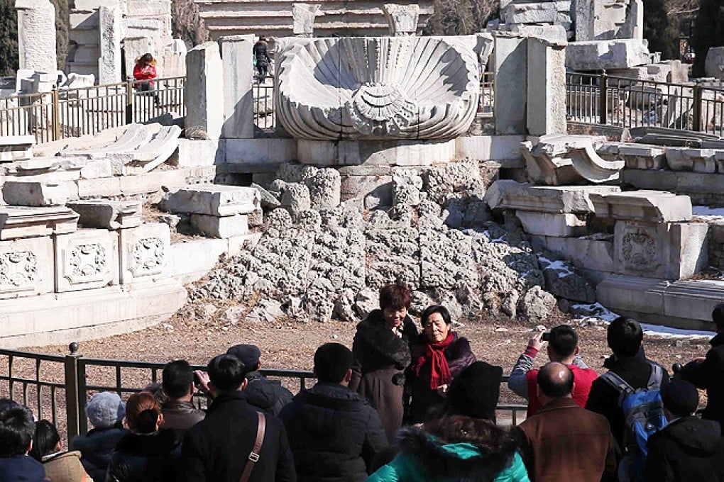 Visitors pose for a photo in front of the Haiyantang Zodiac fountain in the Old Summer Palace, in Beijing. Photo: AFP