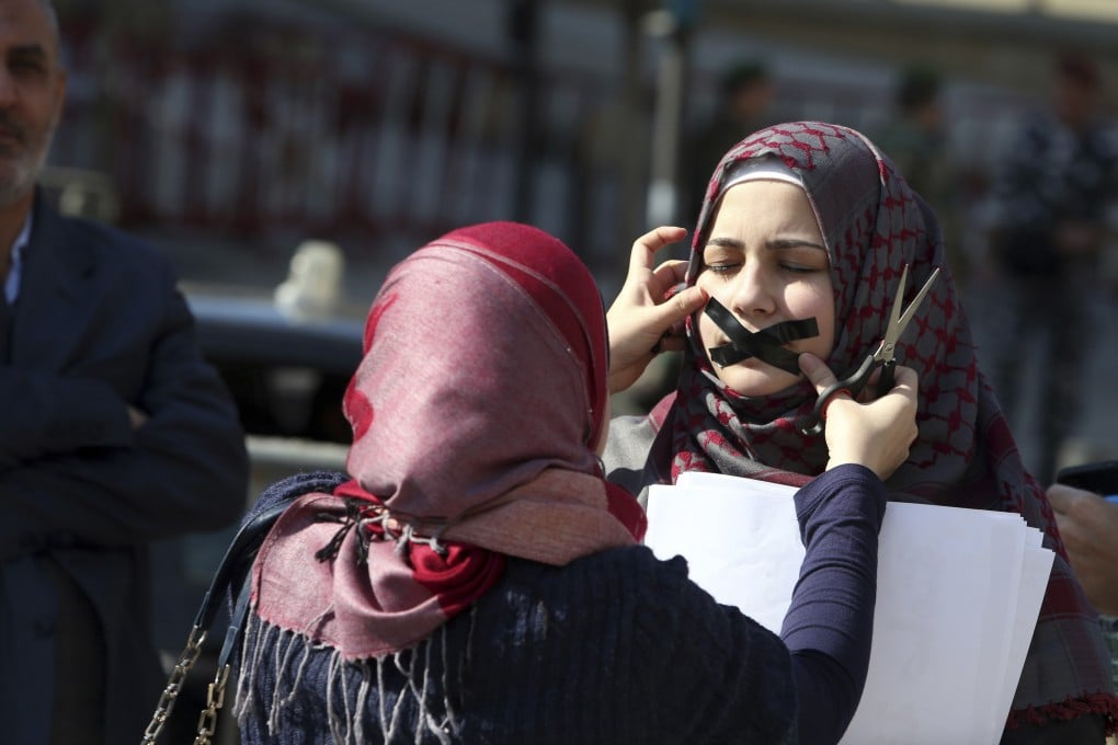 Protesters tape their mouths in protest against the detainment of journalists in Egypt. Photo: Reuters