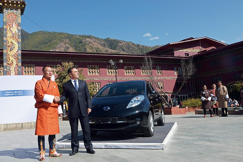 Nissan Motor Corporation chief executive officer Carlos Ghosn (centre right) and Bhutanese Prime Minister Tshering Tobgay shake hands after unveiling the Nissan Leaf electric vehicle in Thimphu on Friday. Photo: AFP