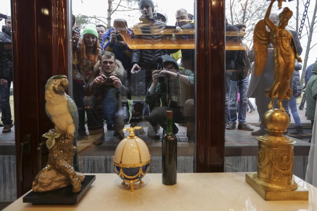 Curious citizens peer through the windows of the palatial main house on the president's expansive Mezhyhirya retreat outside Kiev, taking photos of the over-the-top treasures within. Photo: Reuters