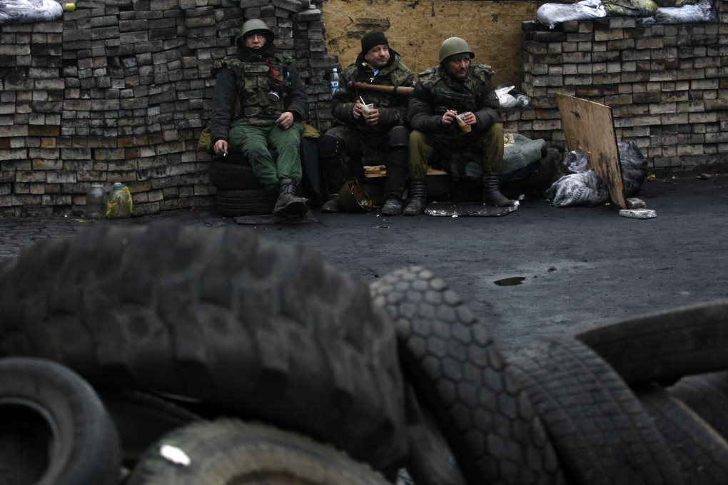 Protesters relax on a barricade at Independence Square in Kiev, Ukraine. Photo: AP