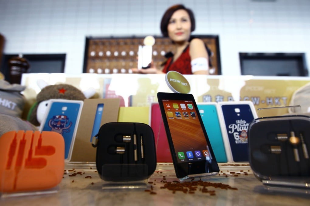 A model pictured with a display of Xiaomi Redmi smartphones at an event in Hong Kong. Photo: SCMP/Jonathan Wong
