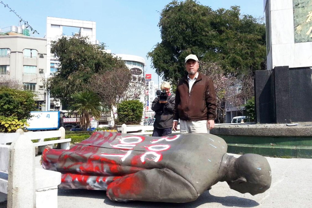 Tsai Ding-gui, chairman of the Alliance of Referendum for Taiwan, stands behind a bronze statue of Sun Yat-sen that was pulled down by dozens of activists. Photo: AFP