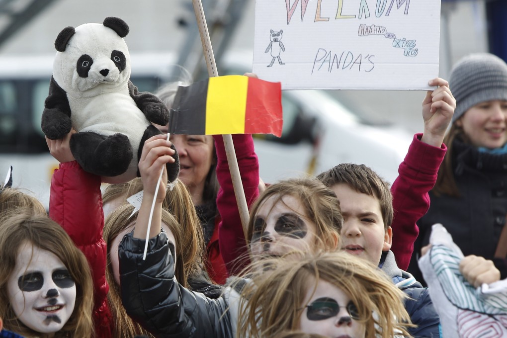 Children welcome giant pandas Xing Hui and Hao Hao at the Brussels National Airport. More people turned up to wave to the pandas on the way to the zoo outside Brussels. Photo: Xinhua