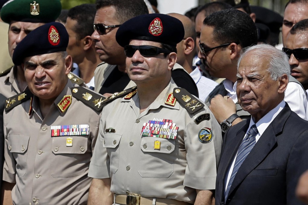 Defence Minister Abdel-Fattah el-Sisi (left) and Prime Minister Hazem el-Beblawi at a funeral in Cairo in September. Photo: AP