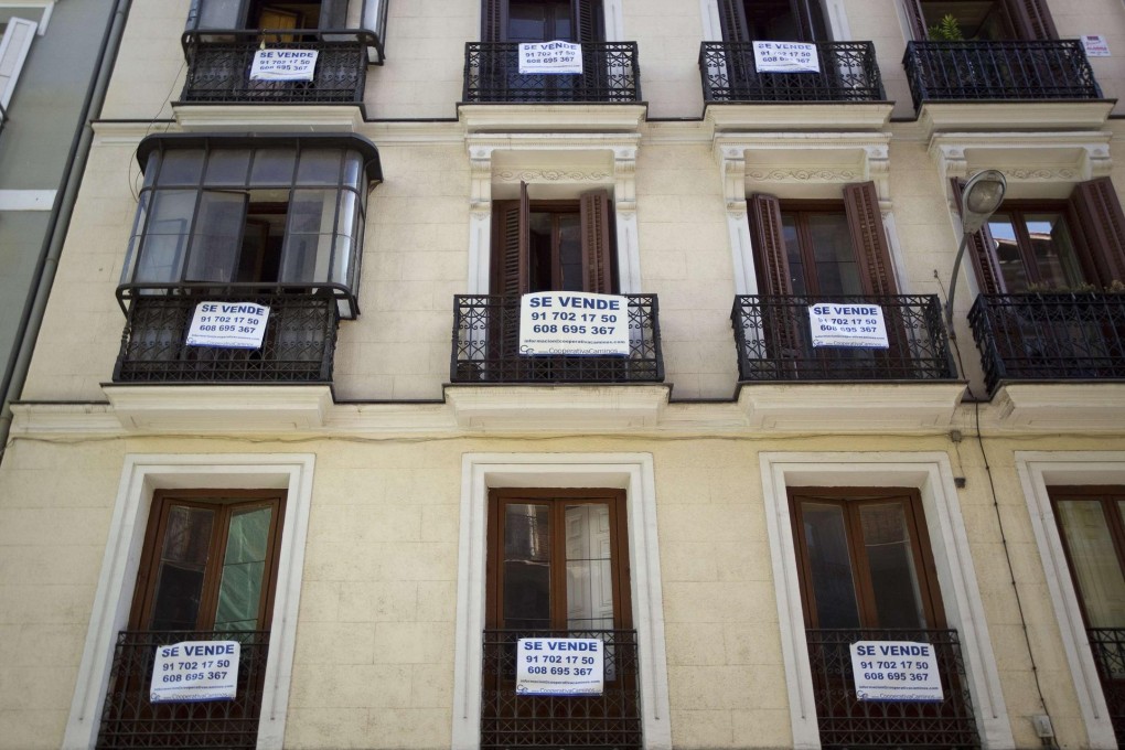 "For Sale" signs hang from balconies in Madrid. Photo: Reuters