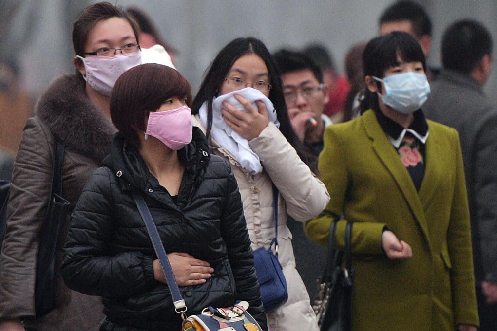 Chinese commuters wear face masks as heavy air pollution continues to shroud Beijing on Tuesday. Photo: AFP