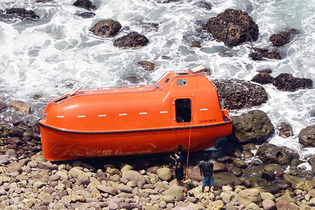 Indonesian villagers stand next to a lifeboat carrying asylum-seekers that washed up on Indonesia's main Java island, with those on board saying Australian authorities transferred them to the vessel and turned it around. Photo: AFP