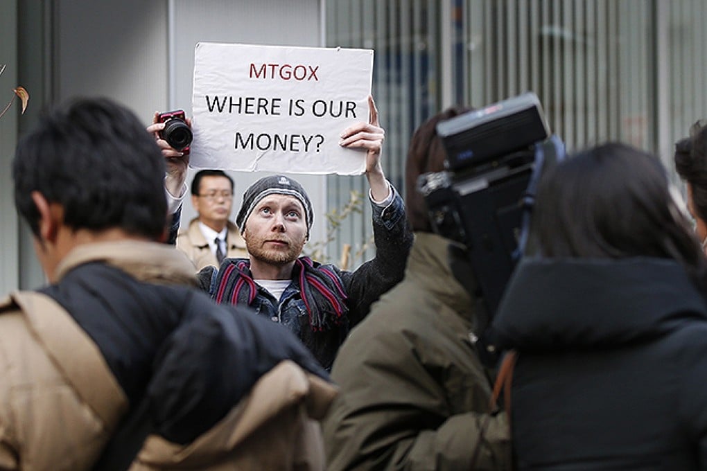Kolin Burges, a cryptocurrency trader from London, holds a placard to protest against the digital marketplace operator Mt Gox in Tokyo. Photo: Reuters
