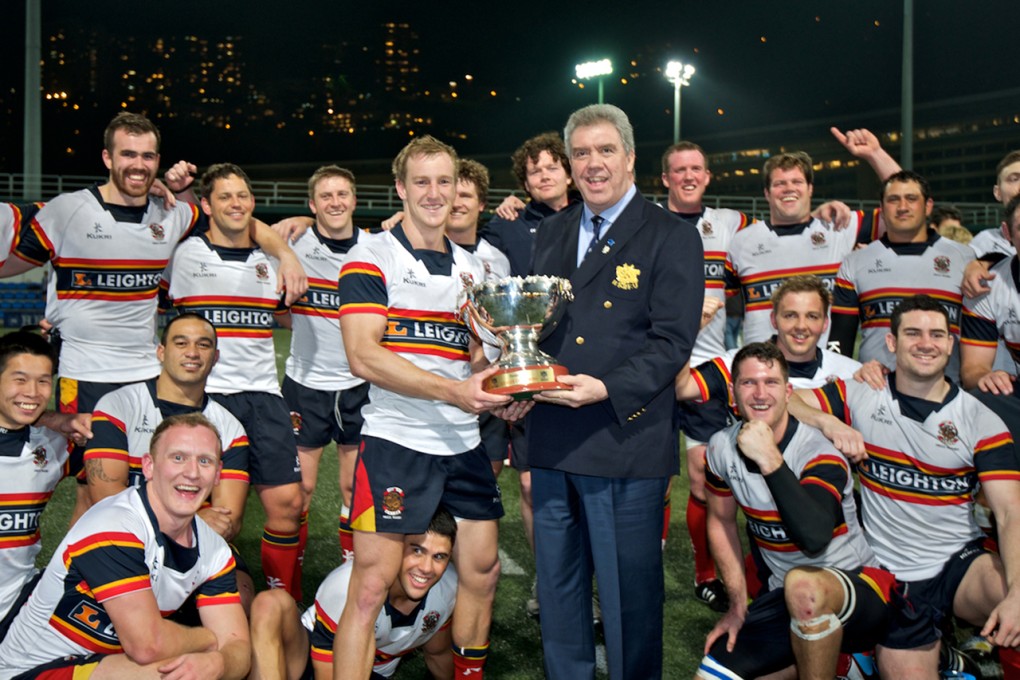 HKRFU chairman Trevor Gregory presents the 2013-14 Premiership league trophy to Alex McQueen of Leighton Asia HKCC. Photo: HKRFU