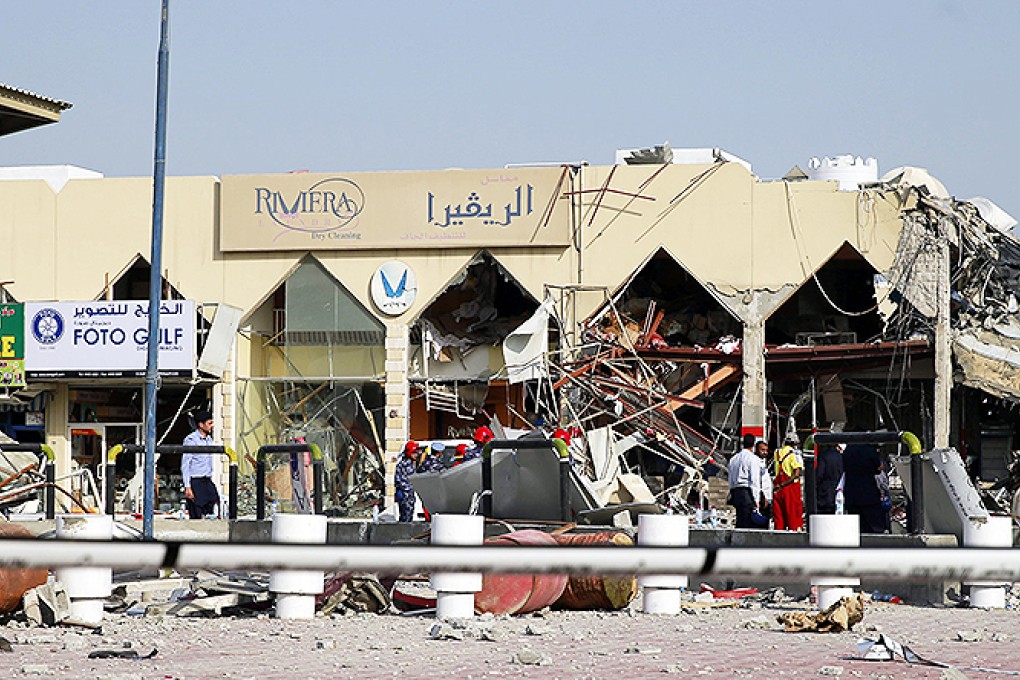 People stand amidst debris near a Turkish restaurant following a gas explosion in Doha. Photo: Reuters