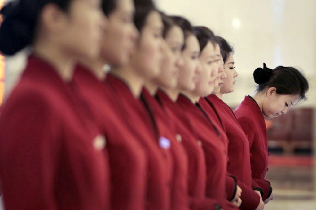 Tea attendants stand in line as they wait to serve delegates during the plenary meeting of the National People's Congress in Beijing. Photo: Reuters