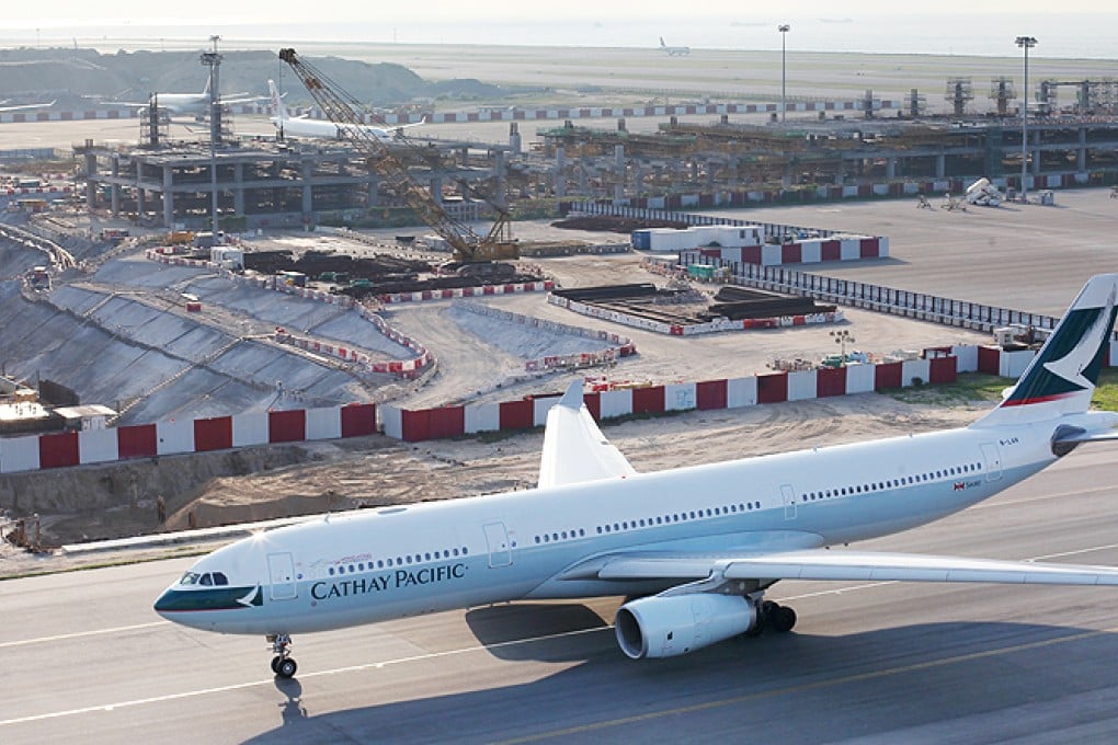 A Cathay Pacific aircraft on the runway adjacent to the construction site of the mid-field development at Hong Kong International Airport. Photo: Nora Tam