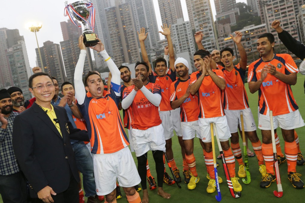 Khalsa captain Inderpal Singh with the spoils of victory as teammates celebrate their league title win over Punjab. Photo: David Wong