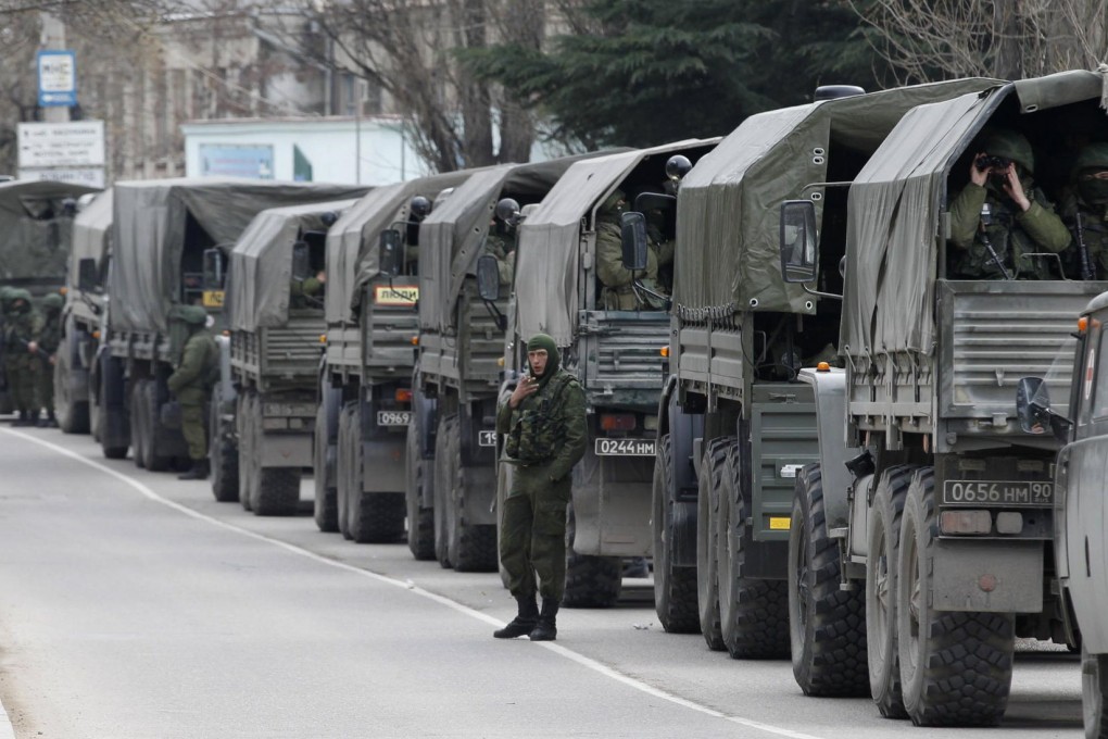 Military personnel sit in Russian military vehicles in the Crimean town of Balaklava. Ukraine has said Russian forces are already in its restive southern region. Photo: Reuters
