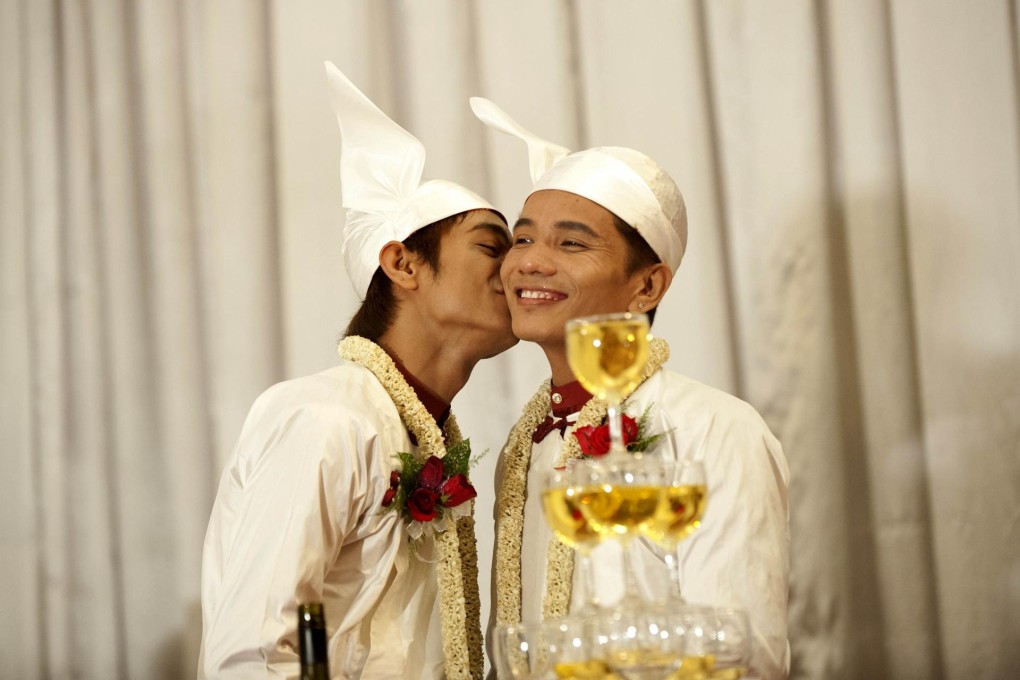 Myo Min Htet kisses Tin Ko Ko at their wedding reception. Photo: AFP