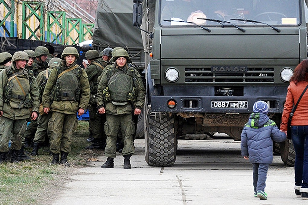 Russian military personnel enter the eastern Crimean port city of Feodosiya. Photo: AFP