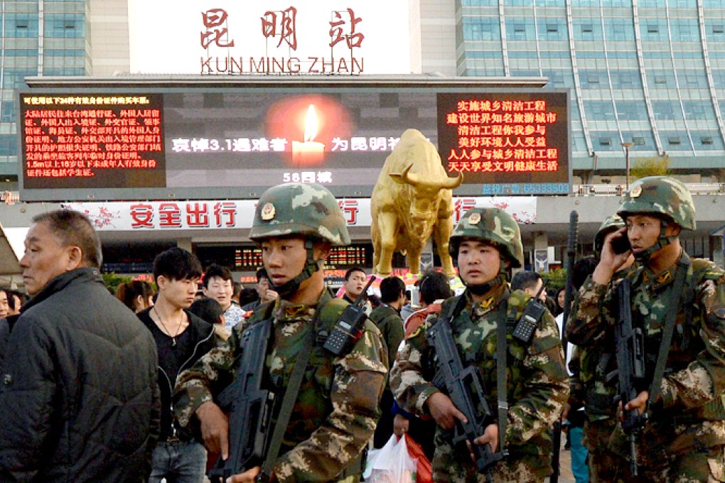 Chinese paramilitary police patrol outside the scene of the attack at the main train station in Kunming on Monday. Photo: AFP